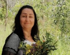 A woman smiling with a bunch of flowers.