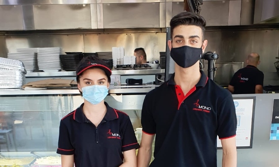 A young woman and man wearing face masks.