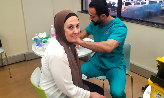 Yamamah receiving her first shot of the COVID-19 vaccine.