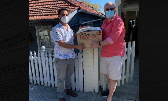 Two men holding a box of devices.