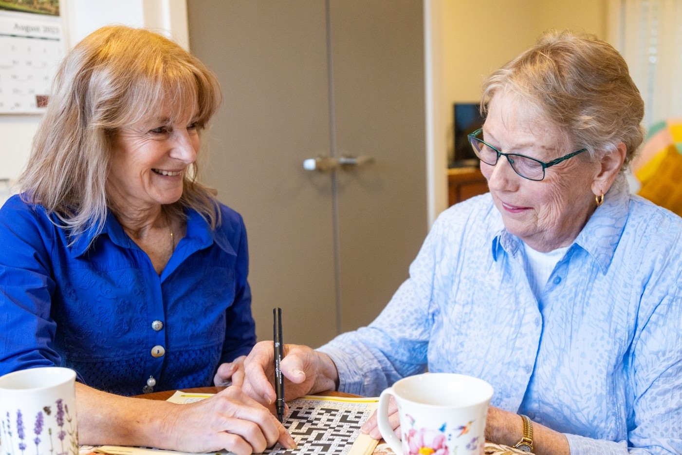 Home Care Worker with senior solving a crossword puzzle