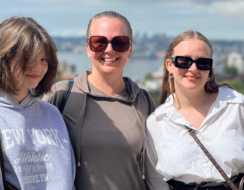 three women smiling outside