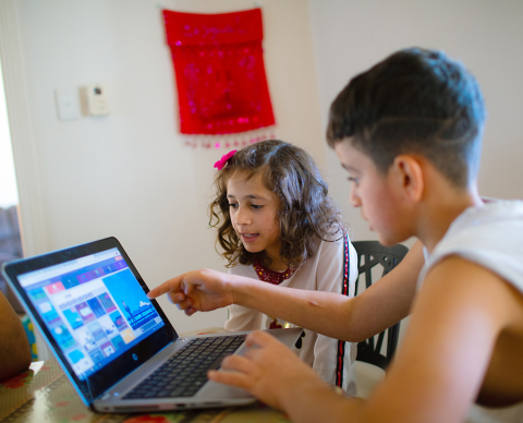 children look at a laptop screen