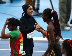 Kimia taking part in athletics event and congratulating opponent.