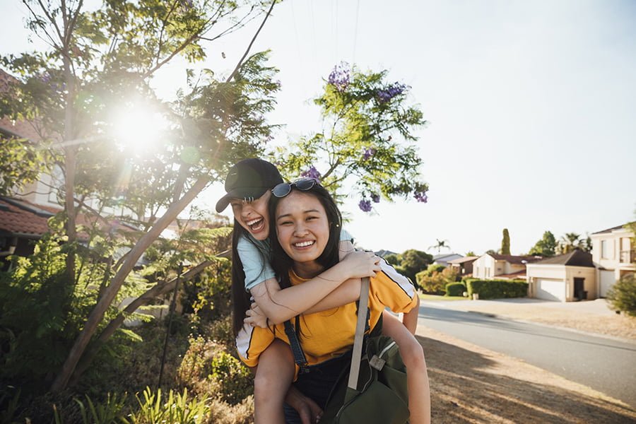 Woman giving a girl a piggy back