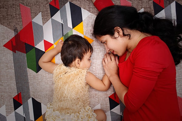 woman lying on ground with sleeping child