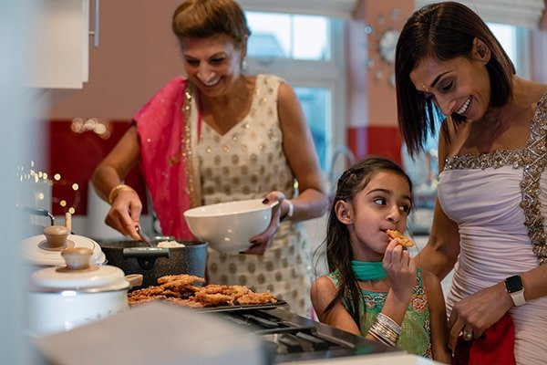 Refugee women in the kitchen cooking with children