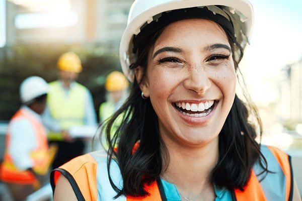 Builder wearing a hard hat and smiling