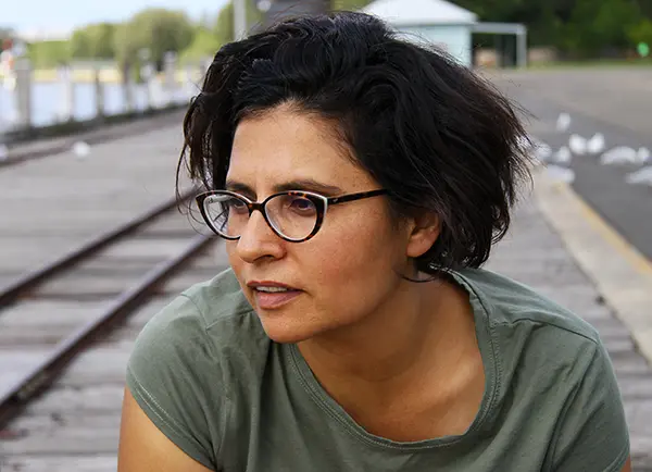 Woman sitting near train tracks