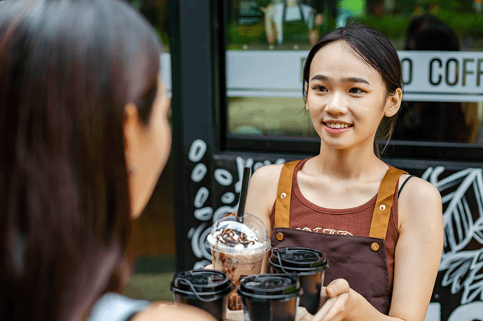 Woman serving coffee to a customer