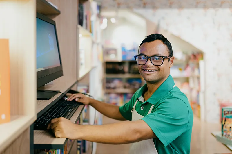 Man working on computer in store to show inclusive employment