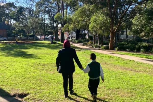 Mother and son walk in park together